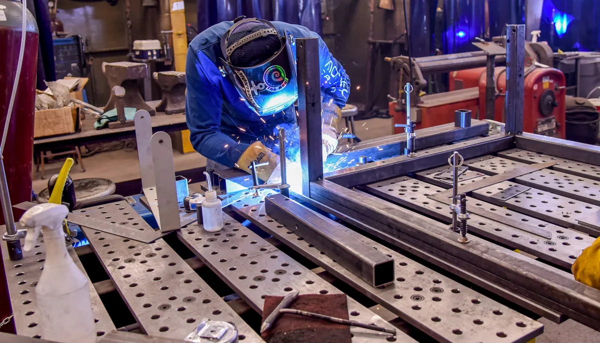 TIG welding fabrication work in progress on a steel weldment fixture