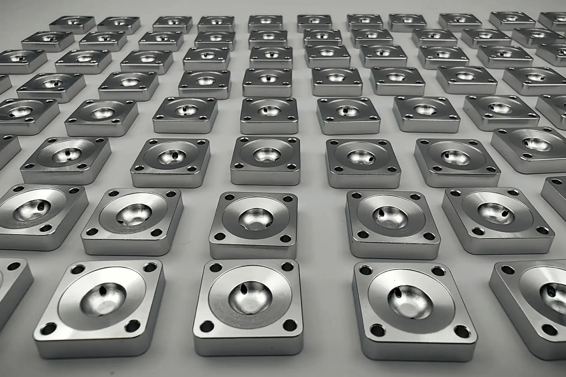 Multiple small precision-machined metal blocks arranged in formation from a production run